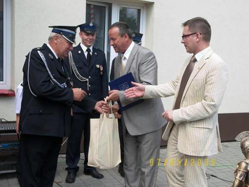 Komendant OSP   w Woli Krzysztoporskiej Zbigniew Galuś przyjmuje gratulacje od Przewodniczącego Rady Powiatu Andrzeja Jarosa.